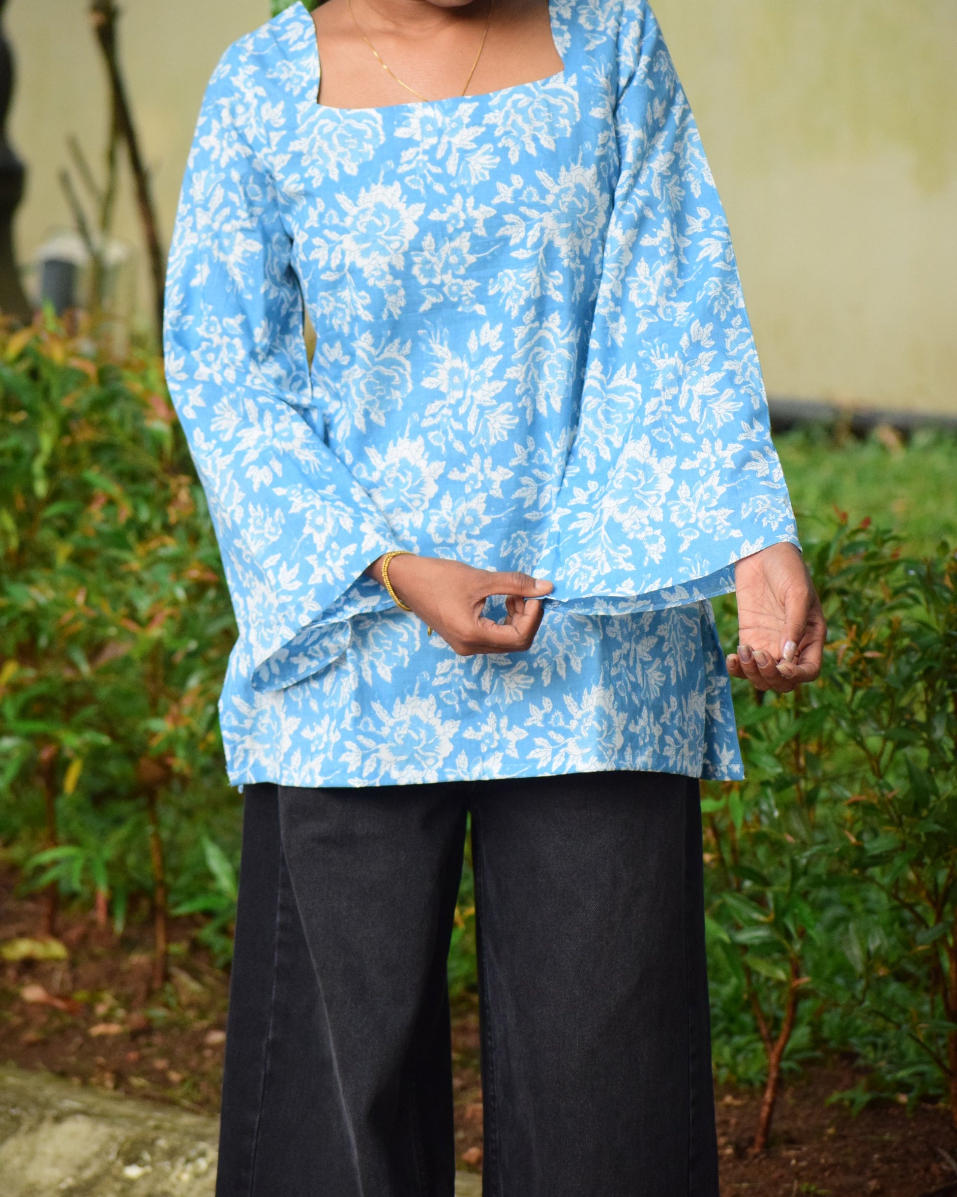Person wearing a blue floral dress with a blurred background