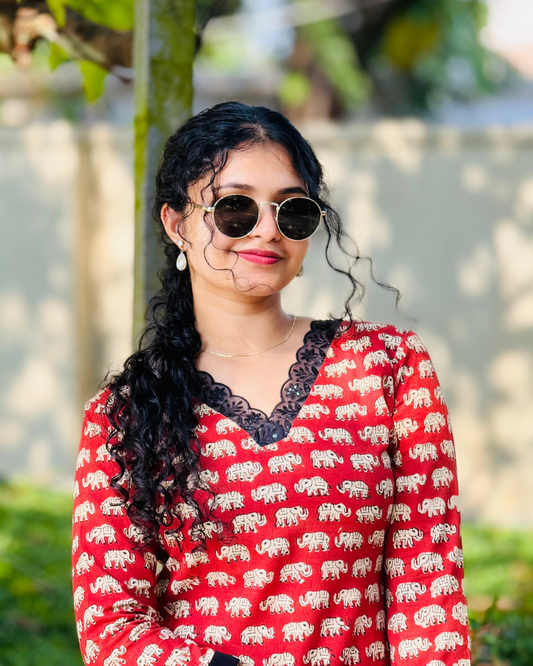 Woman wearing a red shirt with elephant pattern outdoors