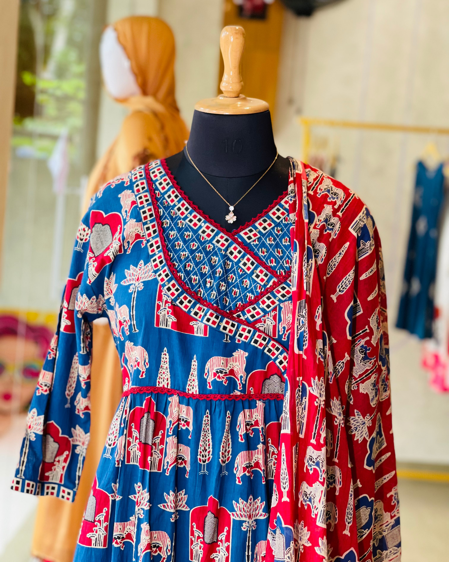 Mannequin wearing a colorful dress with elephant pattern in a store setting