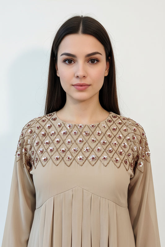 Beige dress with intricate diamond pattern embellishments on a mannequin against a neutral background