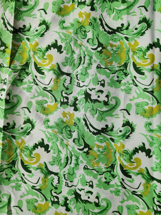 Patterned fabric with green, yellow, and black design on a white background