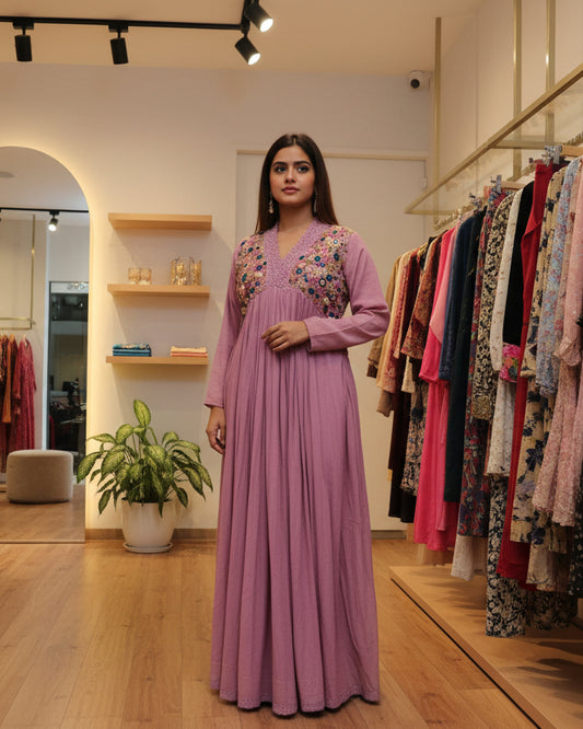 Pink dress with floral embellishments on a mannequin in a store setting.